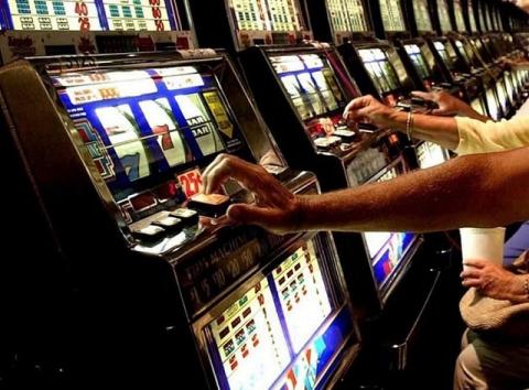 persone che giocano alle slot machines 